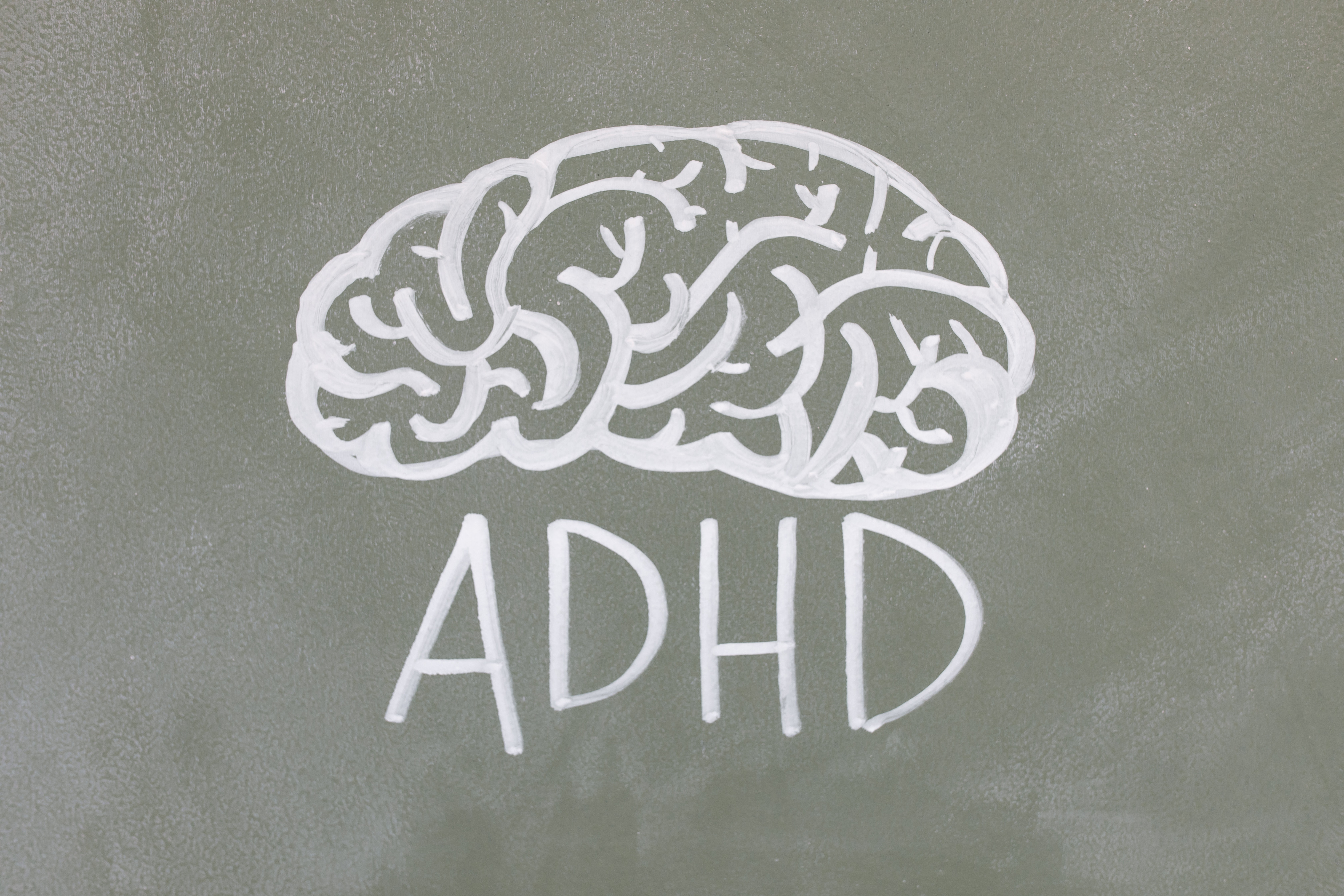 A brain and the word adhd drawn on a blackboard