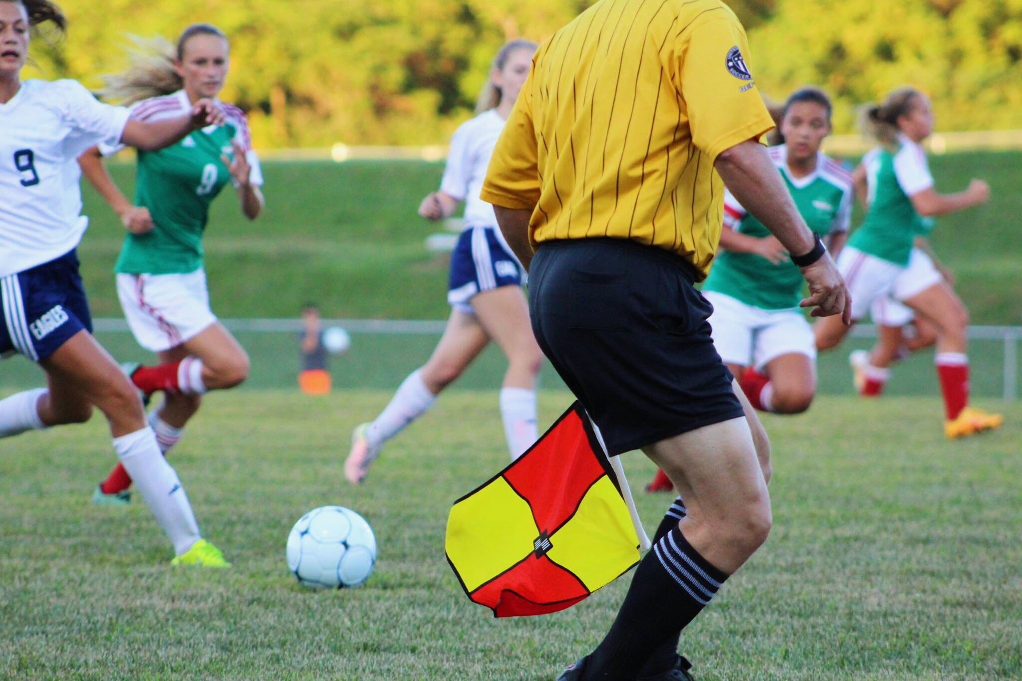 A referee coaching a girls soccer team